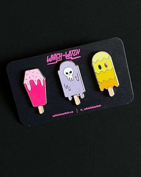 A set of three enamel pins with gothic-themed designs, labeled 'Gothsicle'. The pins are in pastel colors and each has a sticker pack and a postcard included.